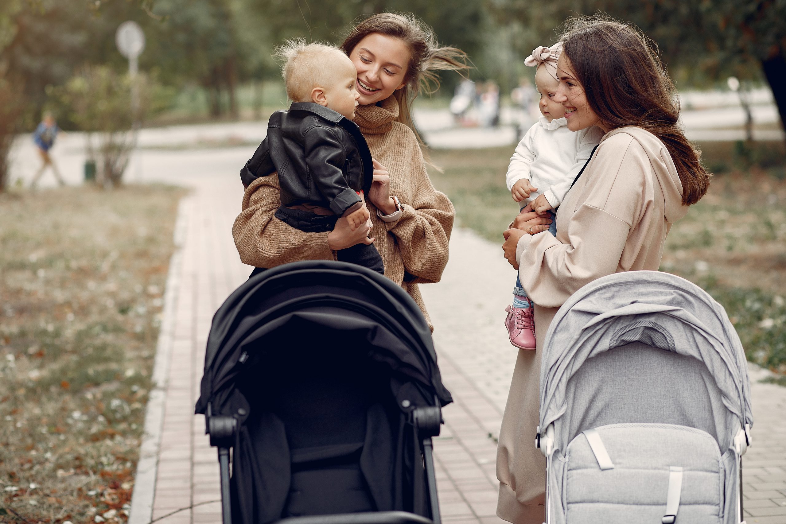 Dwie mamy na spacerze z wózkami w parku – sklepy z wózkami Bielsko-Biała oferujące szeroki wybór
