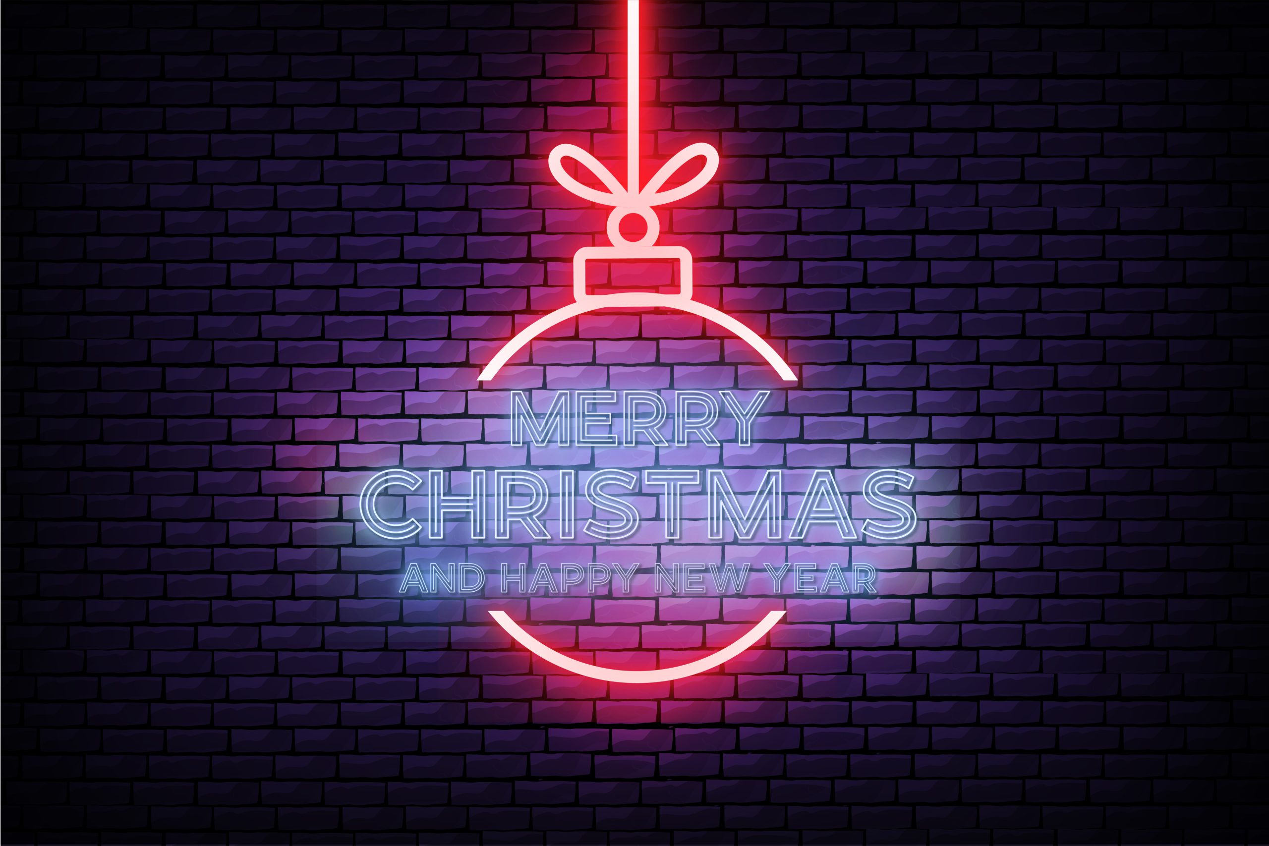 Świąteczny neon w biurze w kształcie czerwonej bombki z kokardą i niebieskim napisem "MERRY CHRISTMAS AND HAPPY NEW YEAR" na tle ciemnej ceglanej ściany.