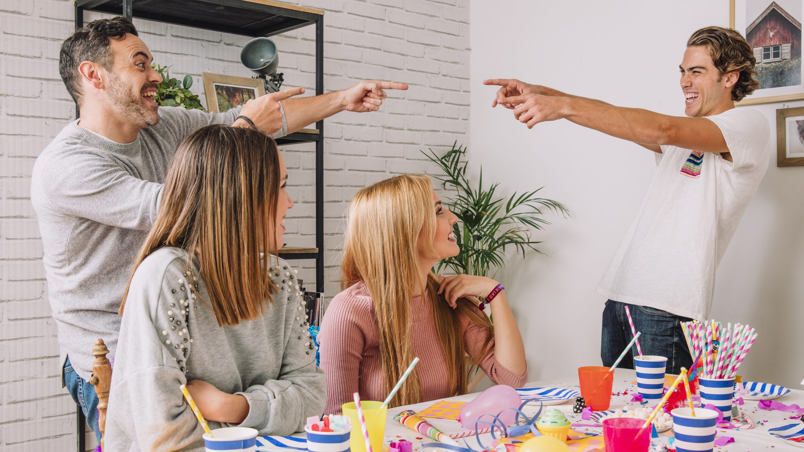 Roześmiani współpracownicy przy wspólnym stole podczas imprezy integracyjne Kraków, uczestniczący w angażujących grach i zabawach budujących relacje w zespole.